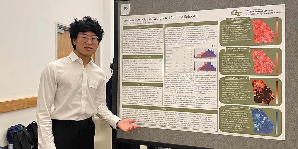 Student presenting in front of a poster
